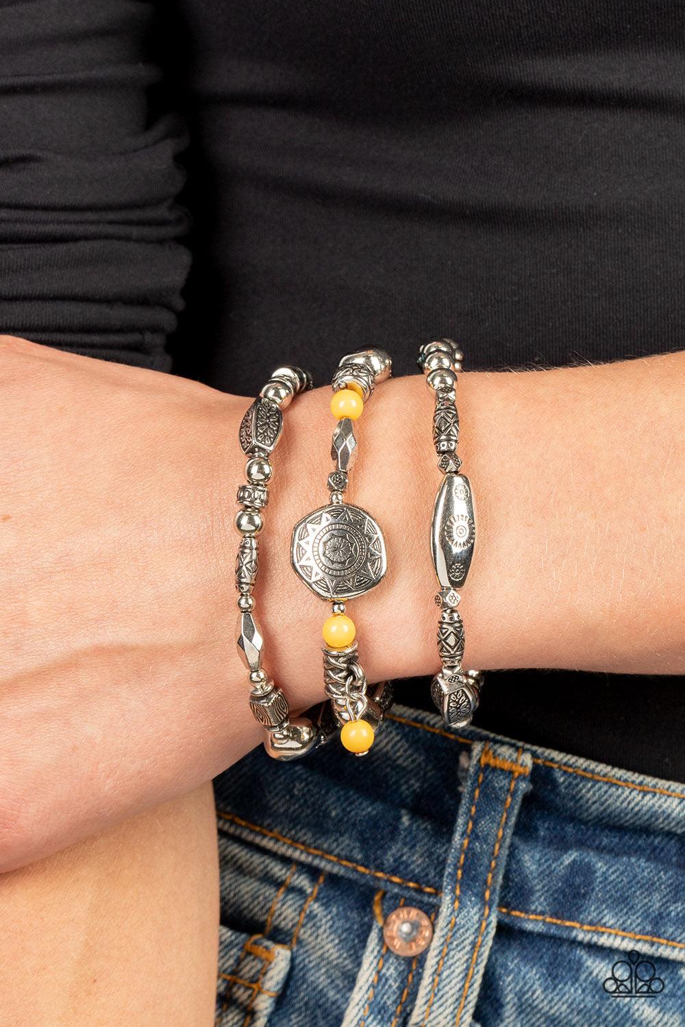 Paparazzi Accessories Western Quest - Yellow Infused with hints of black, Olive Branch, Adobe, and Soybean accents, a mismatched collection of silver beads, textured silver accents, and floral and sunburst embossed beads are threaded along stretchy bands