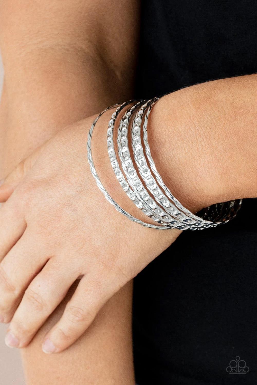 Paparazzi Accessories Back-To-Back Stacks - Silver Embossed in slanted ribbons of textured and studded hammered patterns, trios of mismatched silver bangles stack across the wrist for an intense industrial vibe. Sold as one set of six bracelets. Jewelry