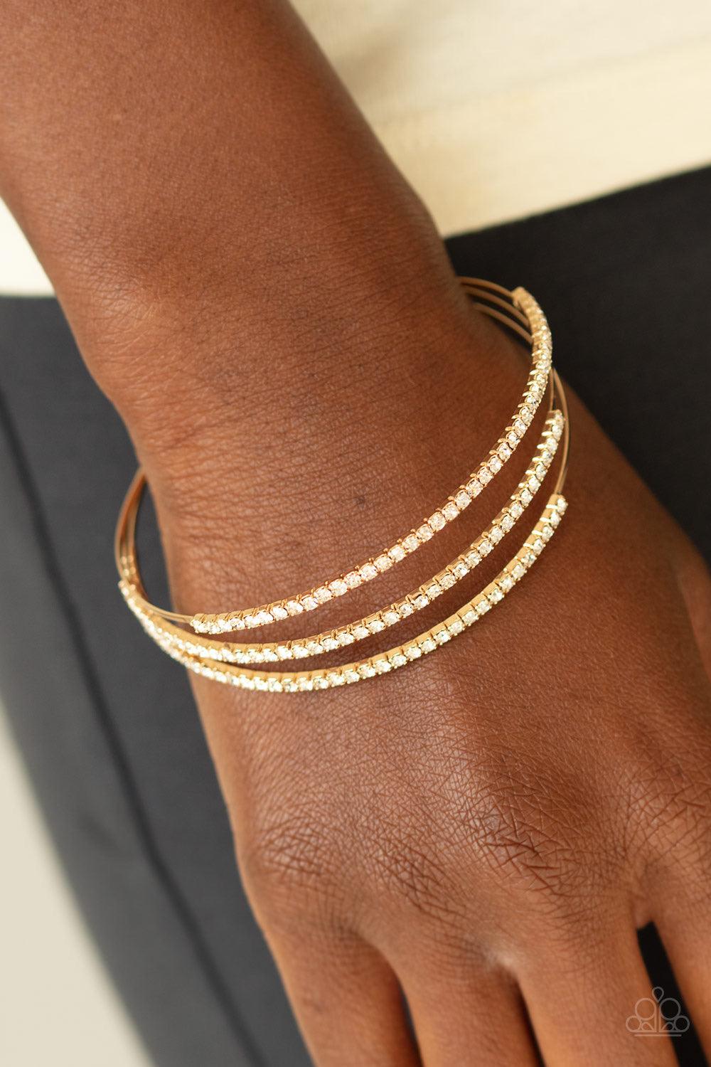 Paparazzi Accessories Iridescently Infatuated - Gold Sections of glittery white rhinestones are encrusted along the tops of three dainty gold bars that coalesce into a glitzy cuff around the wrist. Jewelry