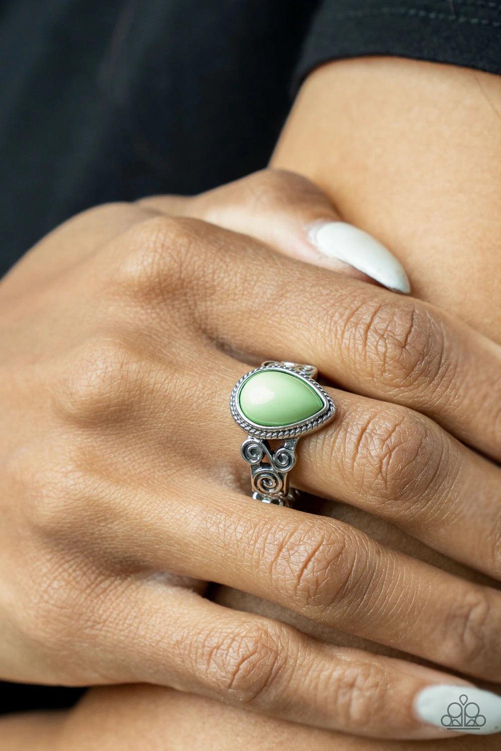 Paparazzi Accessories Dreamt Droplets - Green A dewy Green Ash teardrop bead is pressed into a delicately braided silver frame. Featuring silver filigree scrolls, an airy band creates a dreamy backdrop for the centerpiece as it sits atop the finger. Featu