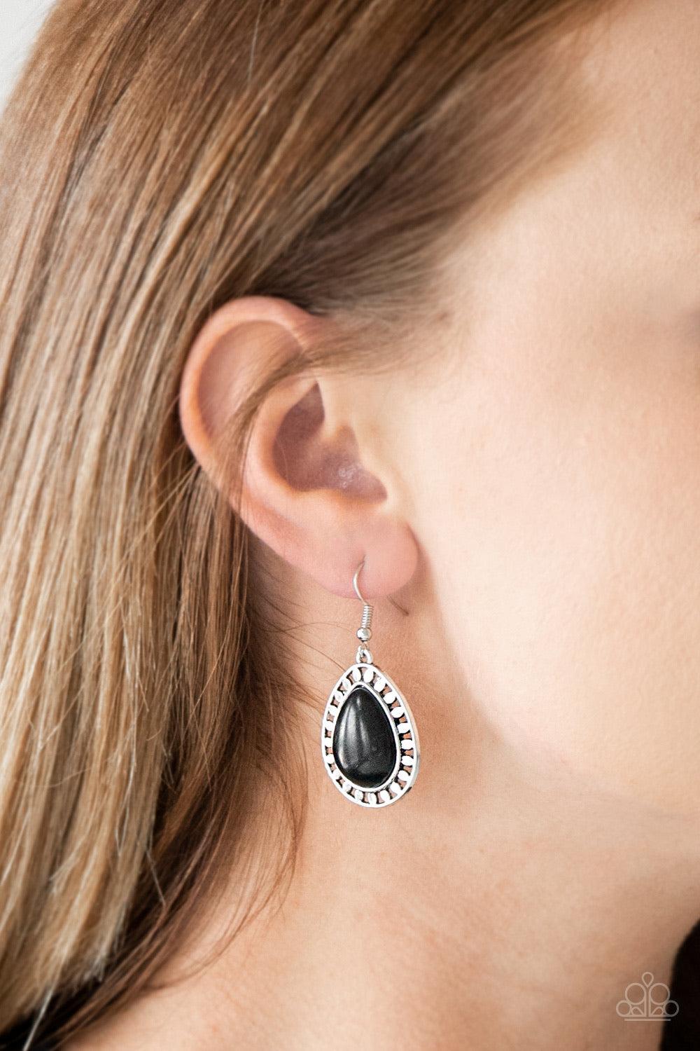 Paparazzi Accessories Sahara Serenity - Black Chiseled into a tranquil teardrop, a smooth black stone is pressed into a shimmery silver frame radiating with tribal inspired textures for a seasonal look. Earring attaches to a standard fishhook fitting. Sol