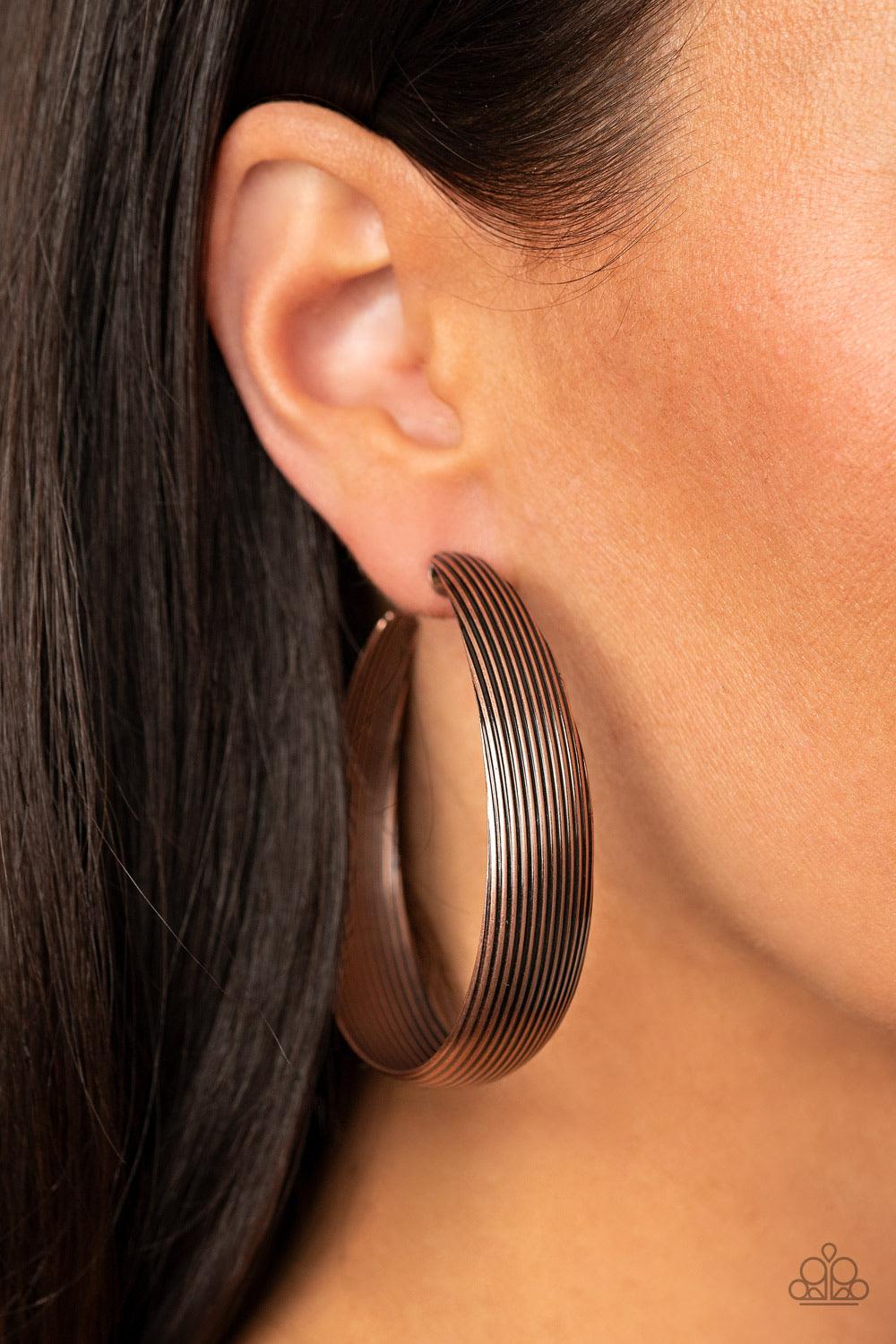 Paparazzi Accessories Desert Wandering - Copper Lined in antiqued ridges, a thick copper hoop curls around the ear for an authentically rustic look. Earring attaches to a standard post fitting. Hoop measures approximately 2 ¼” in diameter. Sold as one pai