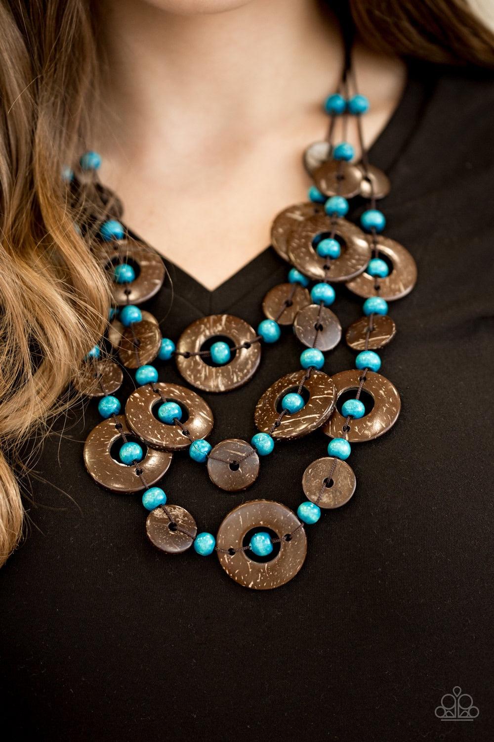 Paparazzi Accessories Bahama Bungalow - Blue Brushed in a distressed finish, wooden discs link into three summery rows below the collar. Round blue beads are knotted between the wooden accents, adding colorful accents to the seasonal palette. Features a b