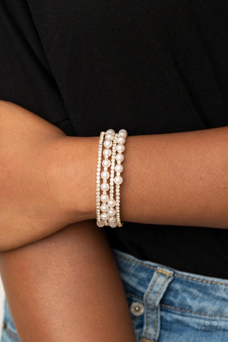 Paparazzi Accessories Starry Strut - Gold Row after row of glassy white rhinestones and classic pearls coil around the wrist, creating a blinding infinity wrap bracelet. Sold as one individual bracelet. Jewelry