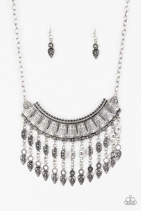 Paparazzi Accessories The Desert is Calling - Silver Stenciled in tribal inspired details, shimmery silver plates connect below the collar, coalescing into a crescent pendant. Embossed and studded in ornate patterns, antiqued silver beads swing from the b