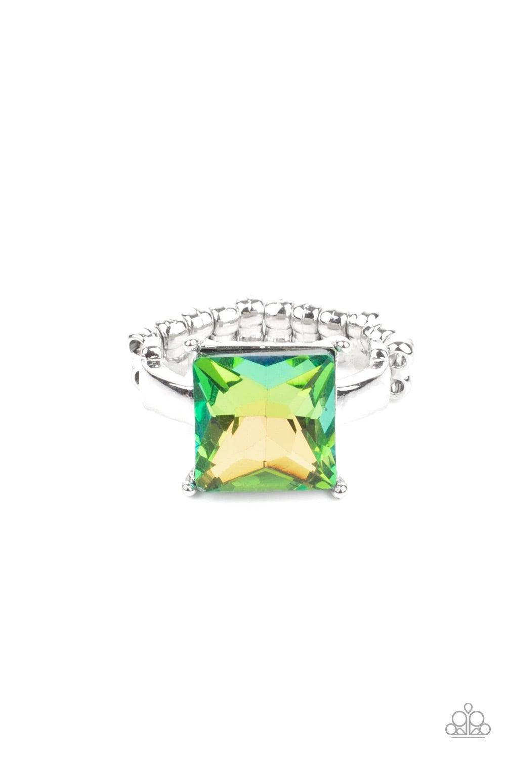 Paparazzi Accessories Ready For My Coronation- Green Featuring a stellar UV shimmer, an oversized princess cut rhinestone shines brilliantly atop a dainty silver band for a sparkly finish. Features a dainty stretchy band for a flexible fit. Sold as one in