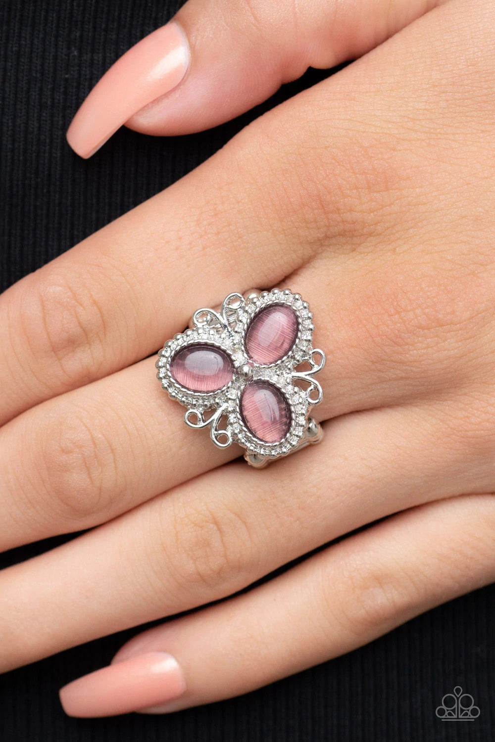 Paparazzi Accessories Bewitched Blossoms - Purple Three oval purple cat's eye stones are encased in studded silver fittings featuring filigree accents, blooming into a magical floral centerpiece atop the finger. Features a stretchy band for a flexible fit