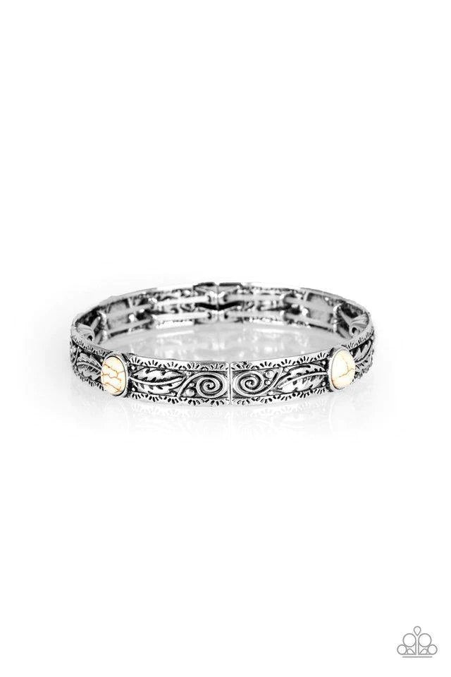 Paparazzi Accessories Wild West Story - White Embossed in swirling silver and feather like detail, antiqued silver frames are threaded along stretchy bands around the wrist. Refreshing white stones adorn the centers of the Southwestern frames for a season