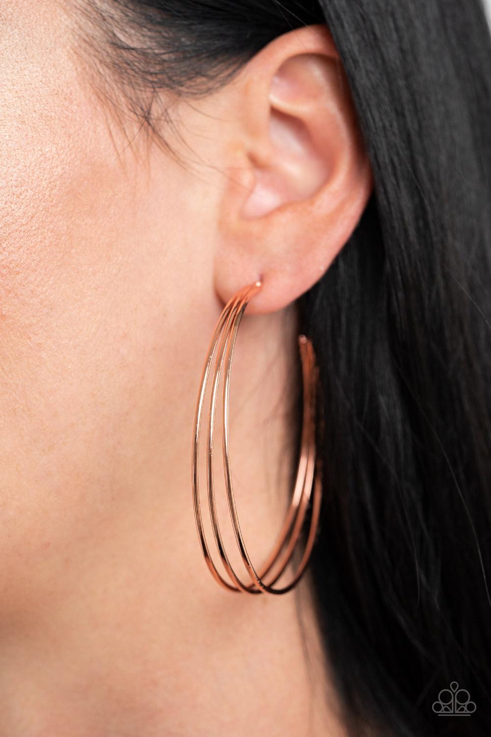 Paparazzi Accessories Rimmed Radiand - Copper A trio of shiny copper hoops are stacked into a dramatically layered display. Earring attaches to a standard post fitting. Hoop measures approximately 2 1/2" in diameter. Sold as one pair of hoop earrings. Jew