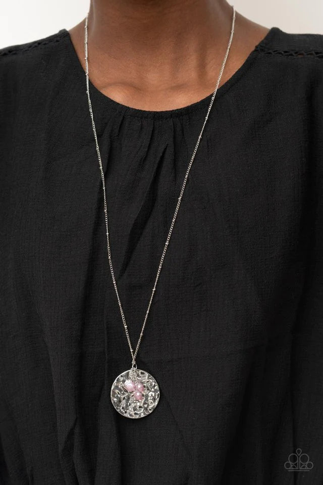 Paparazzi Accessories Seaside Shimmer - Purple A shimmering wavy silver disc sways from the bottom of a lengthened silver satellite chain. A cluster of light purple pearl beads dangles charmingly in front of the disc creating a tranquilly mystical pendant