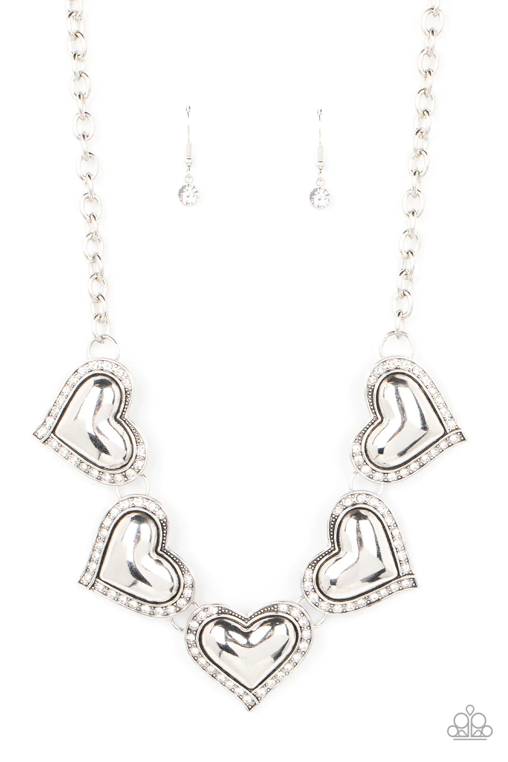 Paparazzi Accessories Kindred Hearts - White Bordered in glitzy hematite rhinestones, an oversized collection of beveled silver heart frames delicately links below the collar for a dramatically romantic look. Features an adjustable clasp closure. Sold as