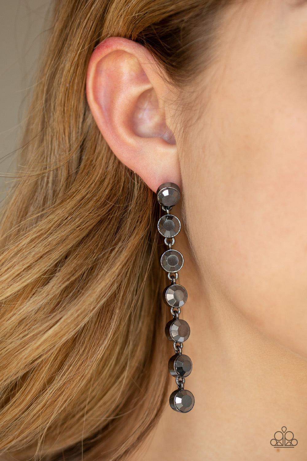 Paparazzi Accessories Dazzling Debonair - Black Featuring sleek gunmetal fittings, a collection of oversized hematite rhinestones drip from the ear for a glamorous look. Earring attaches to a standard post fitting. Jewelry
