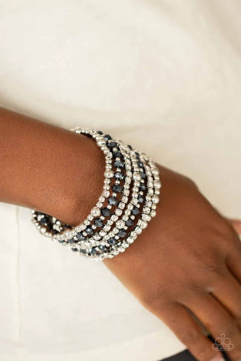 Paparazzi Accessories Ice Knowing You - Blue An icy collection of silver beads, silver cubes, metallic blue crystals, and glassy white rhinestones are threaded along a coiled wire, creating a blinding infinity wrap style bracelet around the wrist. Sold as
