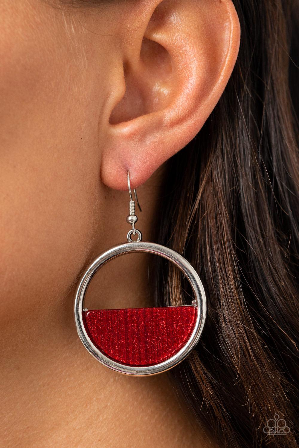 Paparazzi Accessories Stuck in Retrograde - Red A glittering Samba acrylic crescent frame is nestled on the bottom of a shimmery silver hoop, coalescing into a colorfully retro frame. Earring attaches to a standard fishhook fitting. Sold as one pair of ea