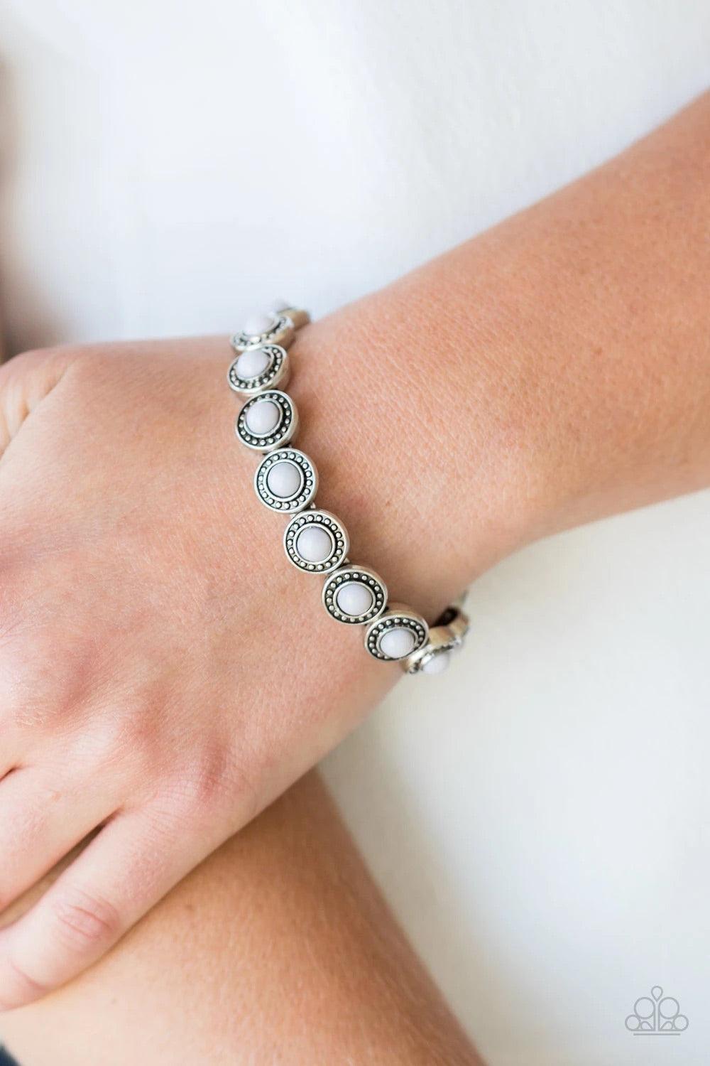 Paparazzi Accessories Globetrotter Goals - Silver Dotted with neutral gray beaded centers, studded silver frames are threaded along stretchy elastic bands and linked around the wrist for a whimsical look. Sold as one individual bracelet. Jewelry