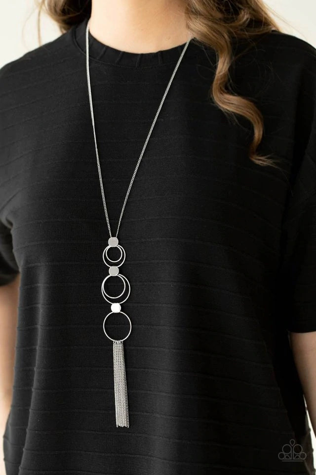 Paparazzi Accessories Join The Circle - Silver A set of concentric silver circles connected by flat silver discs swings from a lengthened silver chain. A soft silver fringe sways from the bottom ring for an elemental approach. Features an adjustable clasp