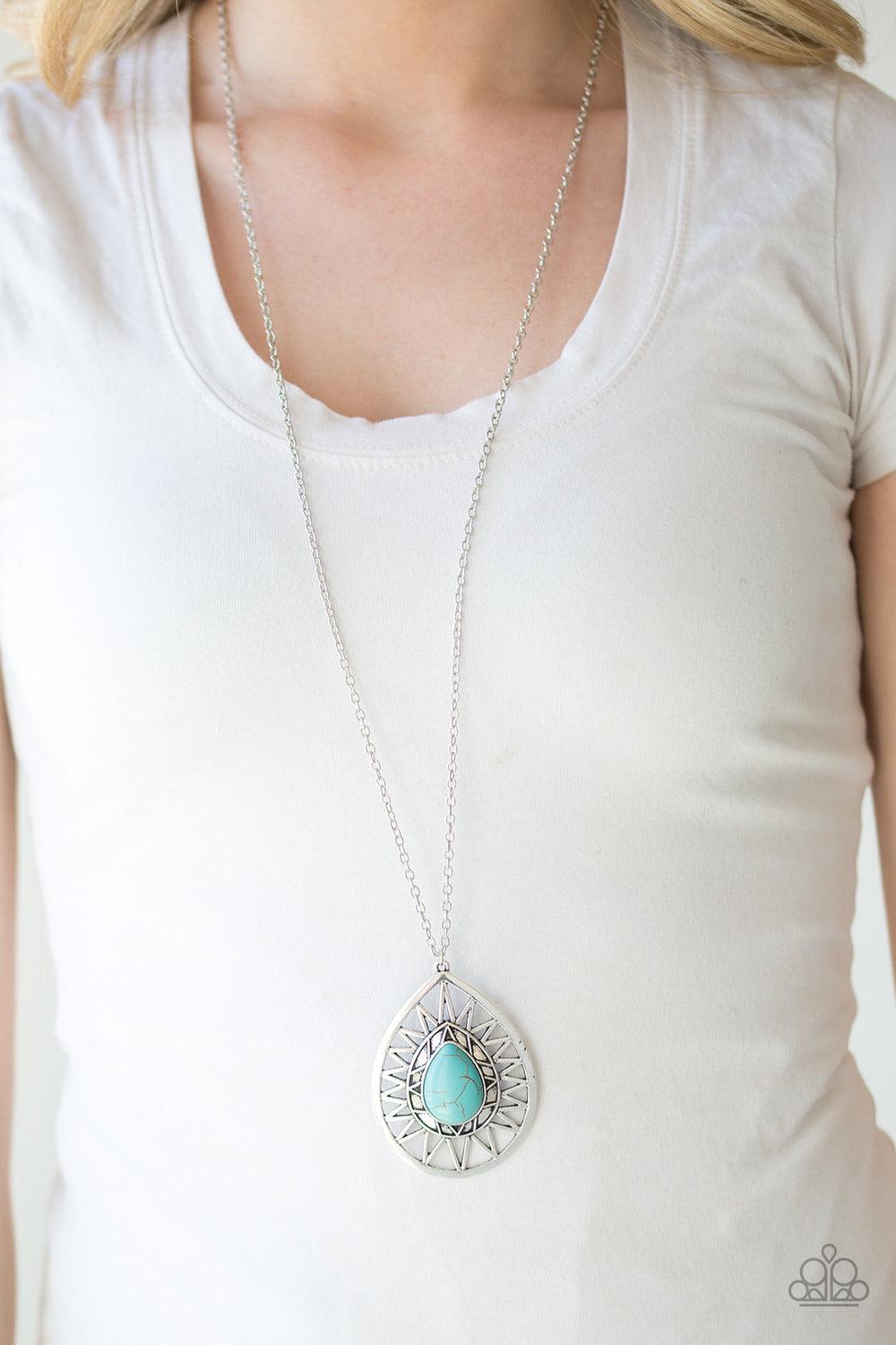 Paparazzi Accessories Summer Sunbeam - Blue A refreshing turquoise stone is pressed into the center of a large silver teardrop radiating with shimmery sunburst patterns. The tribal inspired pendant swings from the bottom of a lengthened silver chain for a