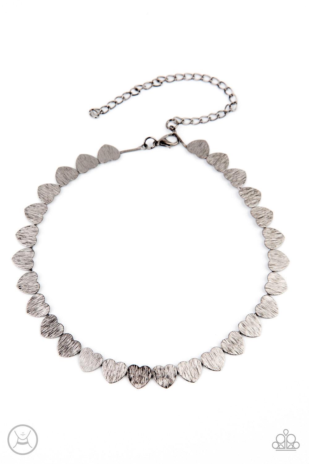 Paparazzi Accessories Playing HEART To Get - Black Featuring a shimmery scratch finish, a dainty collection of shiny gunmetal heart frames connect around the neck for a flirtatious look. Feature an adjustable clasp closure. Sold as one individual choker n