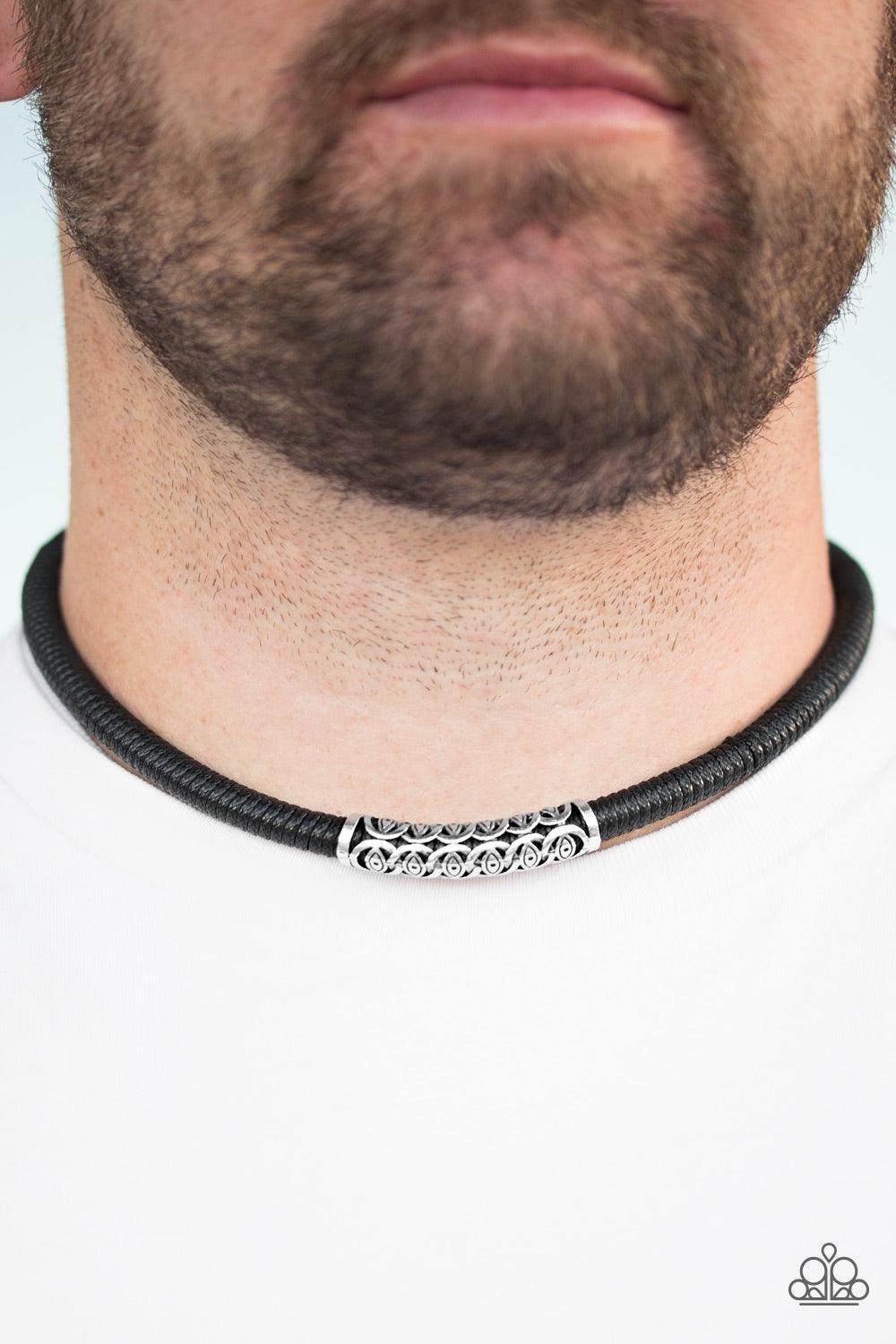 Paparazzi Accessories The Mainland - Black Black cording knots around a leather cord, creating a sleek urban piece below the collar. An ornate silver bead slides along the colorful strand, creating a bold centerpiece. Features a button loop closure. Jewel