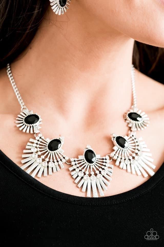 Paparazzi Accessories Miss YOU-niverse - Black Textured metal bars flare out from a mesmerizing black gem, creating a fringe of fanning frames. Sprinkled with white rhinestones, the dazzling display falls just below the collar for a sassy finish. Features