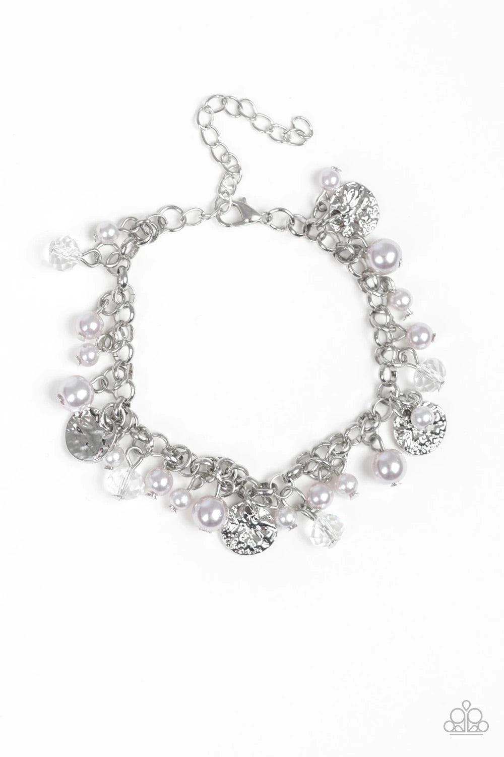 Paparazzi Accessories West Coast Wanderer - Silver Pearly silver beads, smoky crystal-like gems, and hammered silver discs swing from a bold silver chain, creating a refined fringe around the wrist. Features an adjustable clasp closure.Sold as one individ