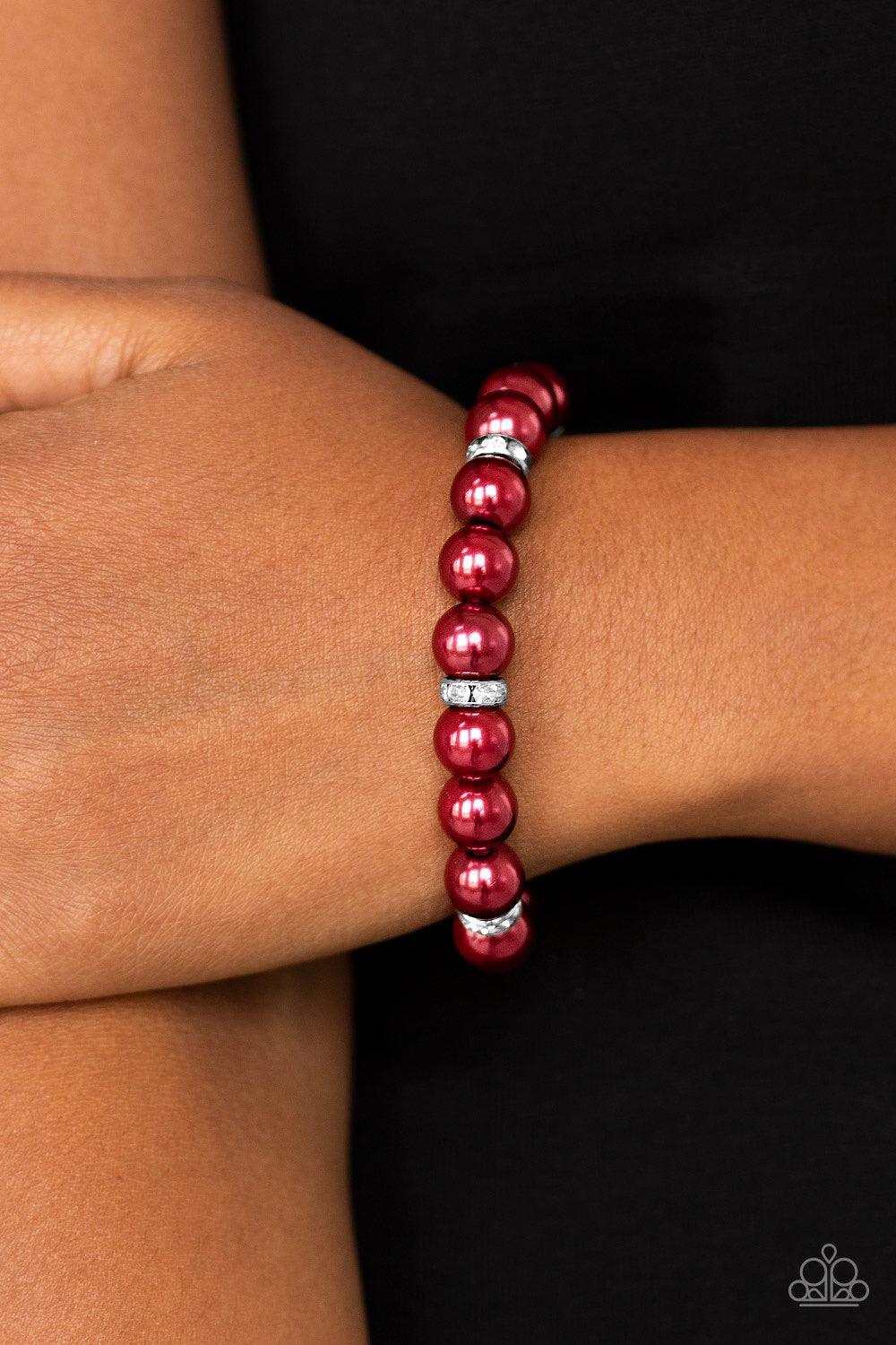 Paparazzi Accessories Exquisitely Elite - Red Classic red pearls and glittery white rhinestone encrusted rings are threaded along a stretchy band, creating a timeless centerpiece around the wrist. Jewelry
