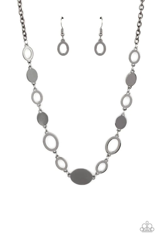 Paparazzi Accessories Working Oval Time - Black A shiny series of glistening gunmetal discs and oval frames delicately link below the collar, creating a casual statement. Features an adjustable clasp closure. Sold as one individual necklace. Includes one