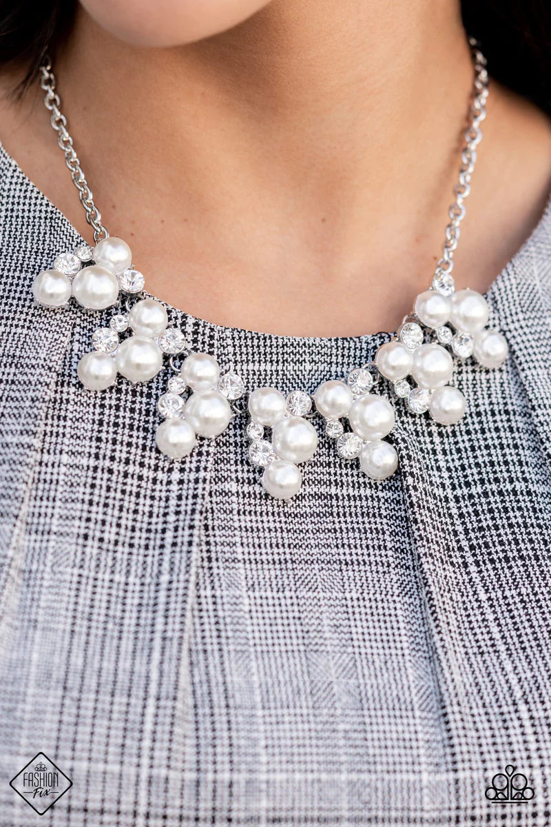 Paparazzi Accessories Renown Refinement - White Vivaciously bubbly pearls and glittering white rhinestones flawlessly meld into a row of abstract teardrop frames. The frames delicately connect to classic silver chains, forming a refined ensemble across th