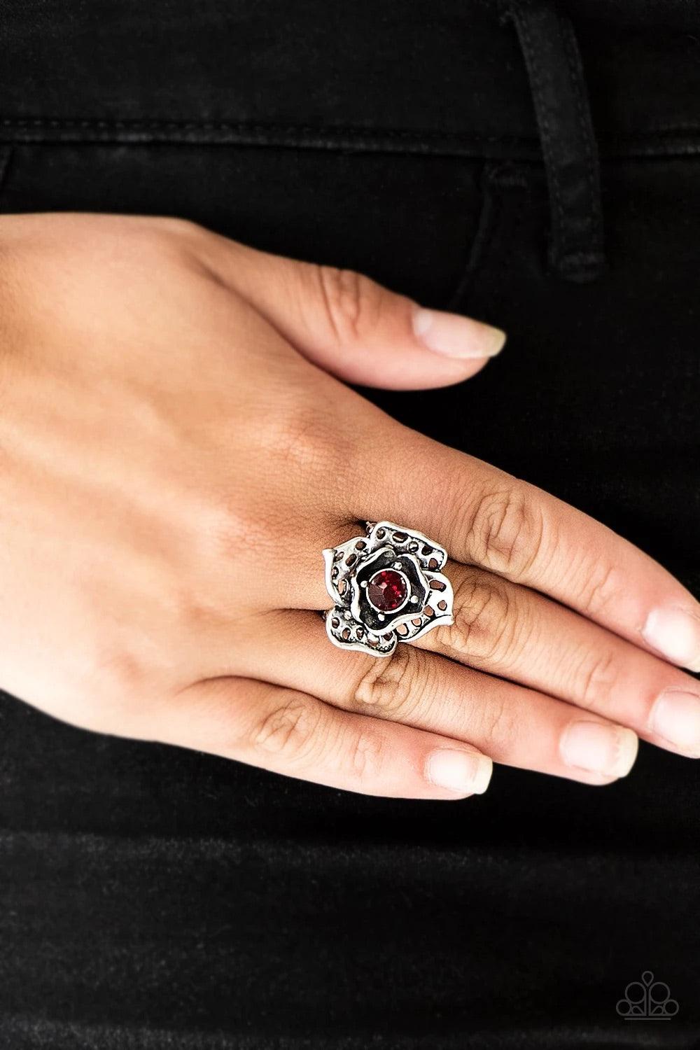 Paparazzi Accessories Glowing Gardens - Red Featuring airy cut-out textures, antiqued silver petals gather around a glowing red rhinestone center for a whimsical look. Features a stretchy band for a flexible fit. Sold as one individual ring. Jewelry