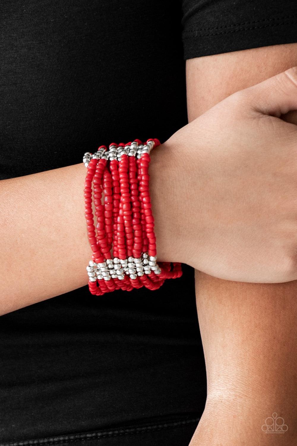 Paparazzi Accessories Outback Odyssey- Red Joined together with metallic fittings, countless red seed beads are threaded along stretchy elastic bands. Sections of dainty silver beads are sprinkled along the colorful layers, adding hints of shimmer to the