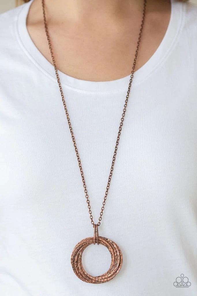 Paparazzi Accessories Metal Marathon - Copper Featuring a hammered finish, a collection of interlocking copper hoops are threaded through the center of textured copper fittings. The dizzying pendant swings from the bottom of a lengthened copper chain for
