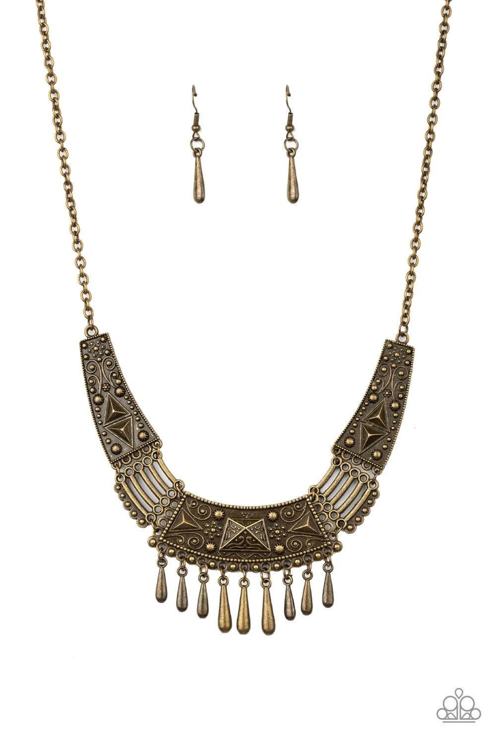 Paparazzi Accessories STEER it Up - Brass Embossed and studded in tribal inspired details, glistening brass plates connect below the collar in a fierce fashion. Dainty teardrop brass beads drip from the center of the pendant, creating a delicate fringe. F