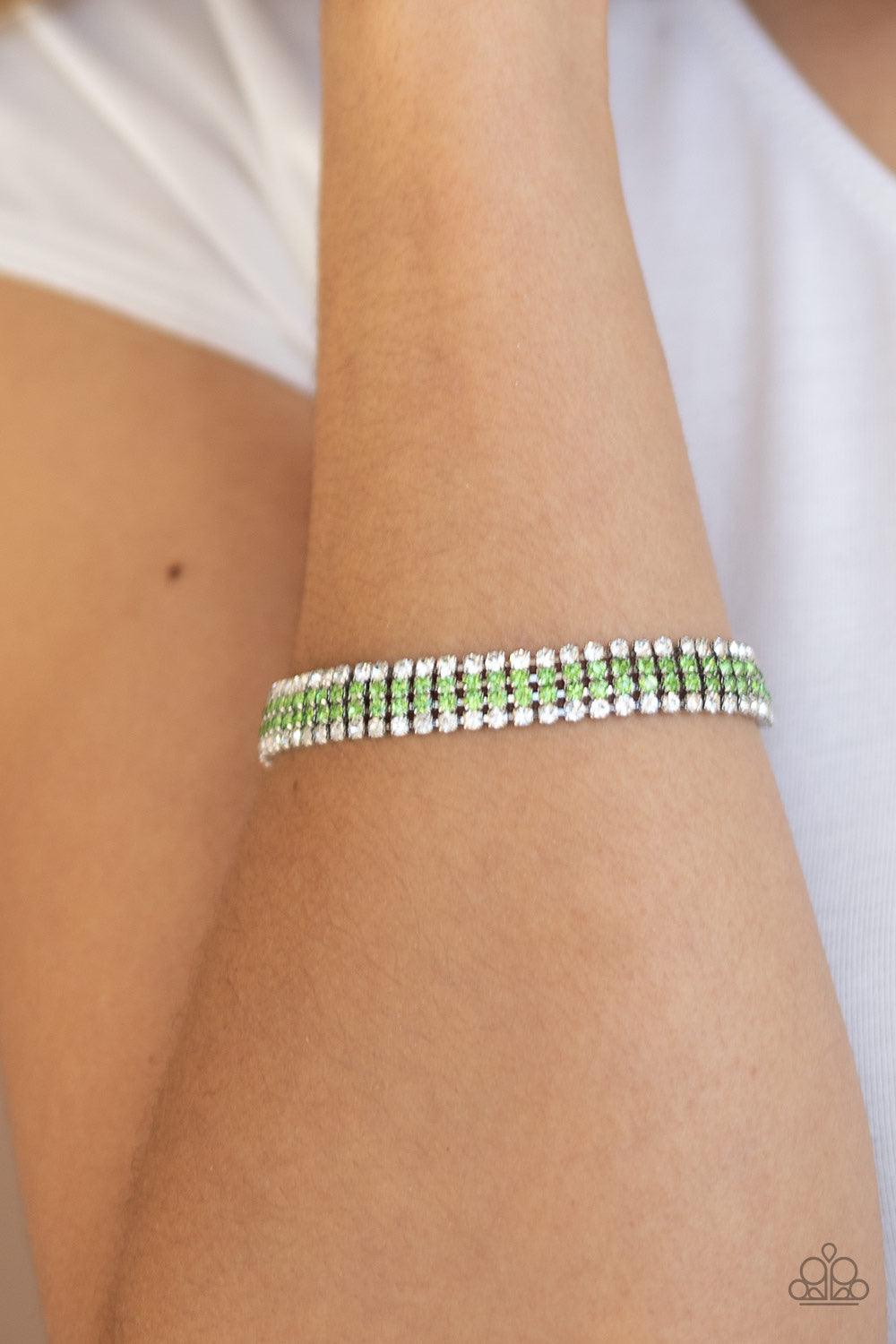 Paparazzi Accessories Color Me Couture - Green Flanked by strands of glassy white rhinestones, two rows of glittery green rhinestones layer across the wrist, coalescing into a single strand of glitz. Features an adjustable clasp closure. Jewelry
