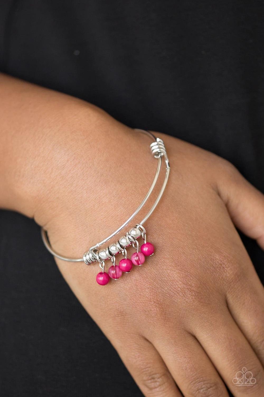 Paparazzi Accessories All Roads Lead to ROAM - Pink Silver wire coils around the wrist, creating an adjustable-like bangle. Glassy pink beads slide between two wire wrap fittings, creating colorful accents along the wrist. Sold as one individual bracelet.