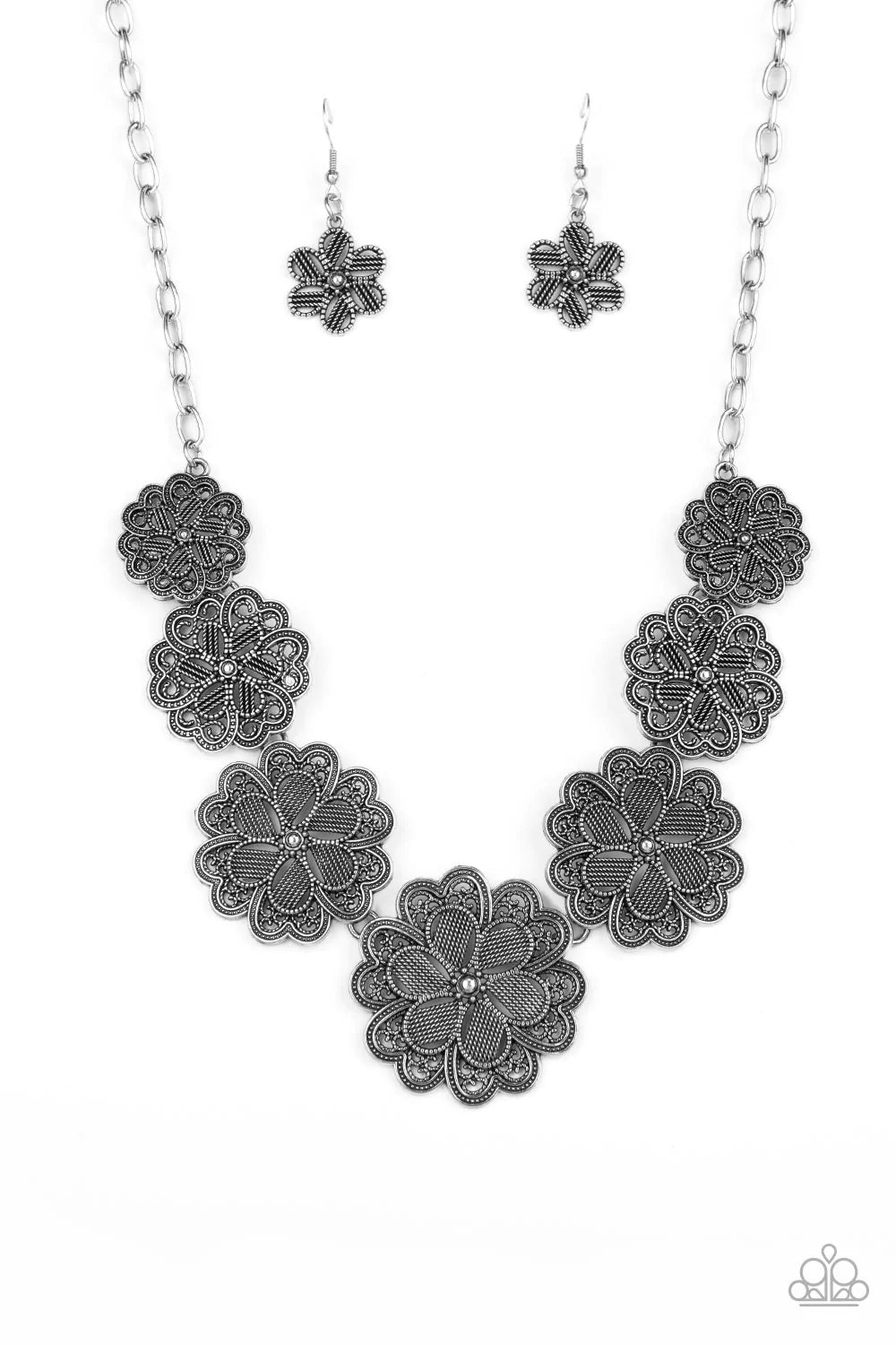 Paparazzi Accessories Basketful of Blossoms - Silver Featuring metallic wicker-like patterns, stacks of teardrop and heart shaped filigree-filled silver petals delicately link into a decorative row of flowers. The floral frames gradually increase in size