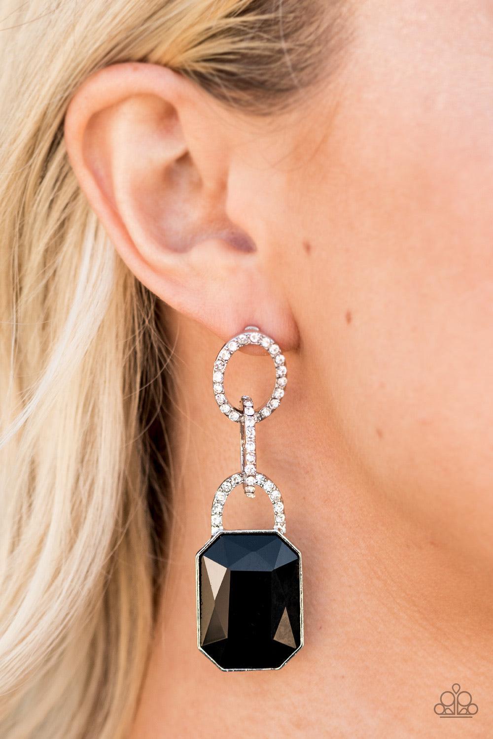 Paparazzi Accessories Superstar Status - Black An oversized black emerald-cut rhinestone swings from the bottom of white rhinestone encrusted links, creating a gorgeously dramatic lure. Earring attaches to a standard post fitting. Jewelry