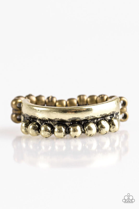 Paparazzi Accessories Glow by Glow - Brass A glistening brass band is dotted in shiny brass studs for an edgy look. Features a stretchy band for a flexible fit. Jewelry