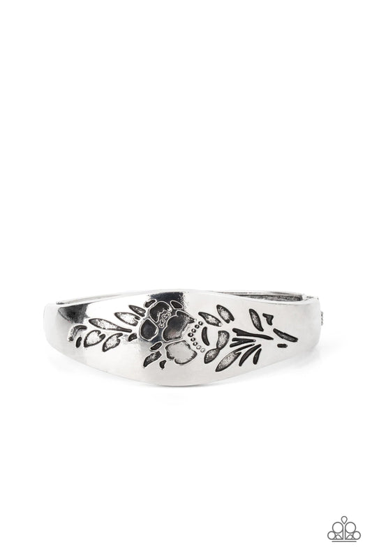 Paparazzi Accessories Fond of Florals - Silver The front of a thick antiqued silver bangle-like bracelet is stamped in a leafy floral pattern, creating a whimsy centerpiece around the wrist. Features a hinged closure. Sold as one individual bracelet. Jewe
