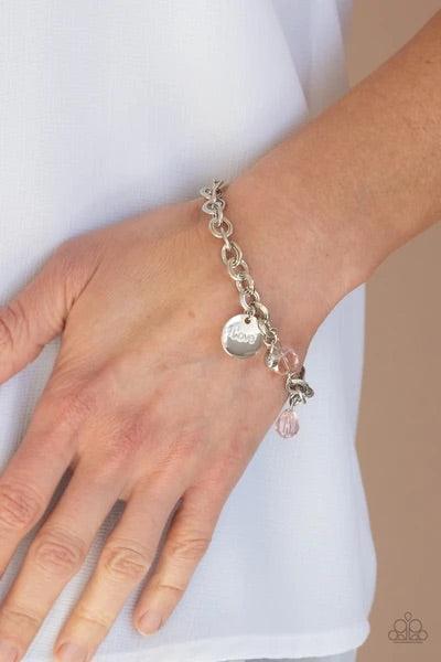 Paparazzi Accessories Lovable Luster - Pink Pink crystal-like beads, a dainty white rhinestone, and a silver disc stamped in the word, "love," adorn a double-linked silver chain, creating a flirty fringe around the wrist. Features an adjustable clasp clos