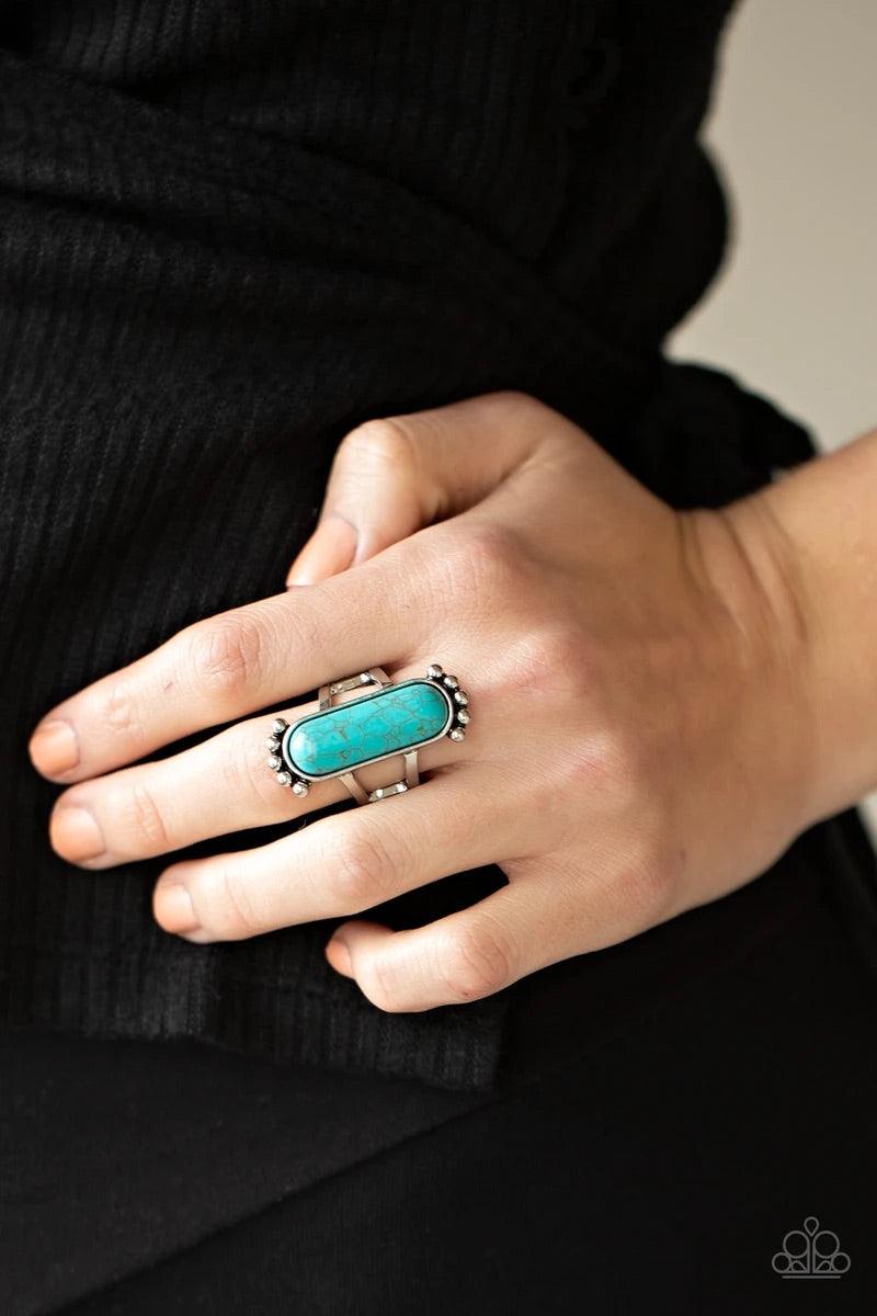 Paparazzi Accessories Ranch Relic - Blue An oblong turquoise stone is pressed into a sleek silver frame featuring a studded top and bottom. The rustic frame sits atop two layered bands, creating a whimsical centerpiece atop the finger. Features a stretchy