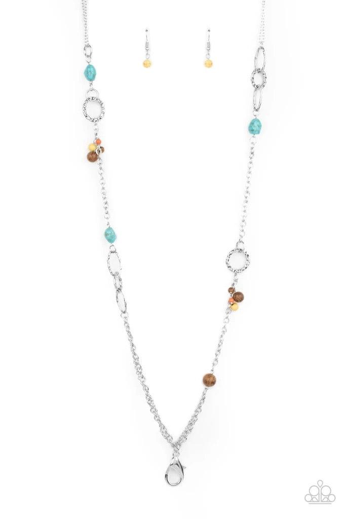 Paparazzi Accessories Sandstone Safari - Multi *Lanyard A mismatched collection of brown wooden beads, turquoise pebbles, hammered silver ovals, and dainty multicolored stone beads haphazardly adorned sections of silver chain across the chest, creating an