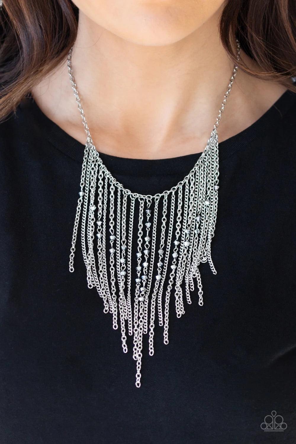 Paparazzi Accessories First Class Fringe - Silver Varying in length, mismatched silver chains stream from the bottom of a classic silver chain. Faceted hematite crystal-like beads sporadically dot the free-falling chains, creating a statement-making fring