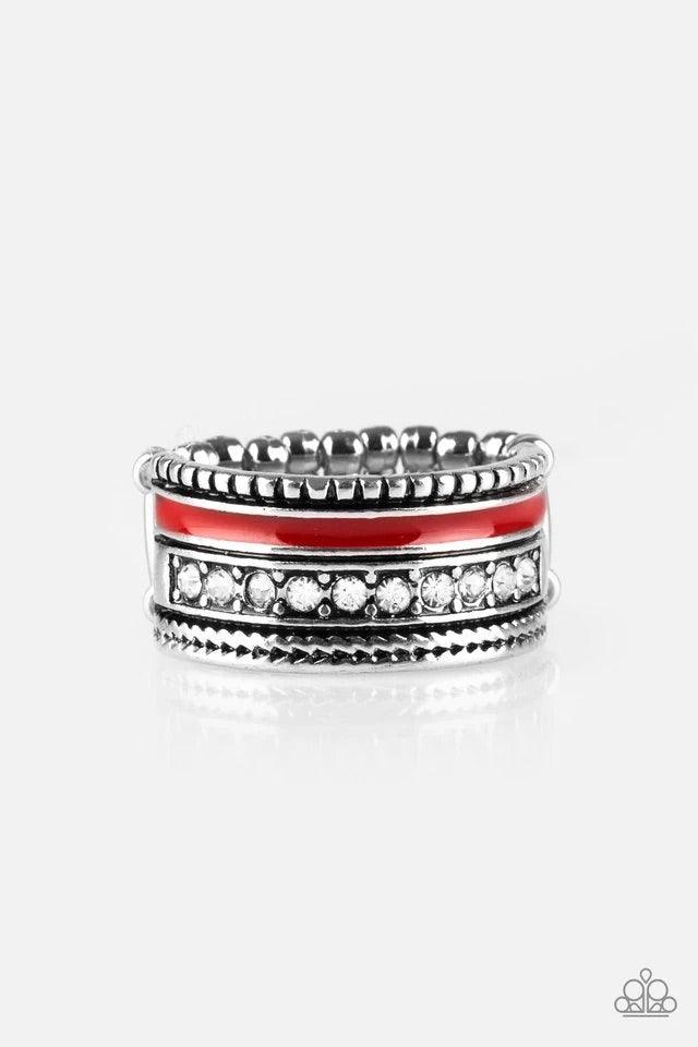 Paparazzi Accessories Rich Rogue - Red A shiny red strip of color runs along the bottom of a row of glassy white rhinestones. Infused with silver textures, the mismatched details coalesce into one thick band across the finger. Features a stretchy band for