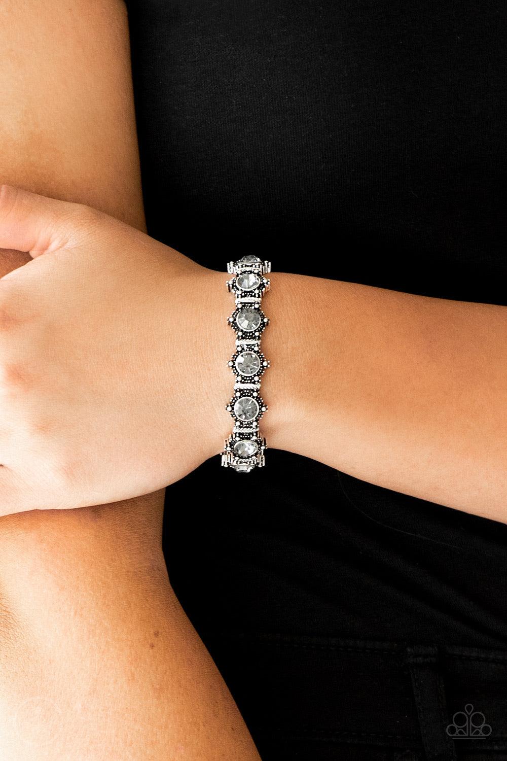 Paparazzi Accessories Strut Your Stuff - Silver Featuring smoky rhinestone centers, ornate silver frames are threaded along stretchy bands, linking across the wrist for a refined look. Jewelry