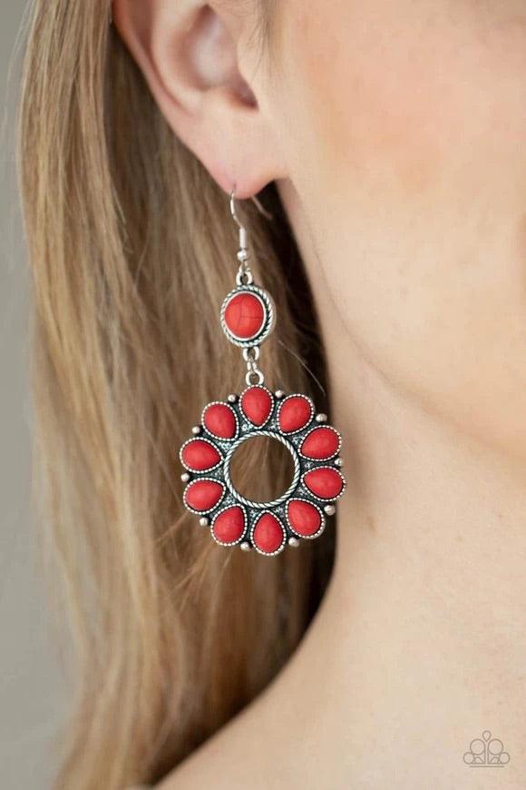 Paparazzi Accessories Back At Ranch - Red A fiery collection of red teardrop stones fan out from a textured silver ring, creating a scalloped floral frame at the bottom of a round red stone dotted frame. Earring attaches to a standard fishhook fitting. So