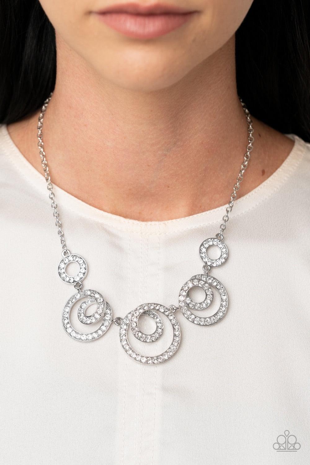 Paparazzi Accessories Total Head-Turner - White Encrusted in glassy white rhinestones, swirling silver frames delicately connect below the collar for a statement-making finish. Features an adjustable clasp closure. Sold as one individual necklace. Include