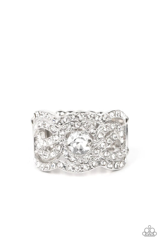 Paparazzi Accessories Doting On Dazzle - White Wavy scalloped rows encased with rhinestones are topped by a central, sparkling rhinestone to provide an elegant and timeless look. Features a stretchy band for a flexible fit. Sold as one individual ring. Je