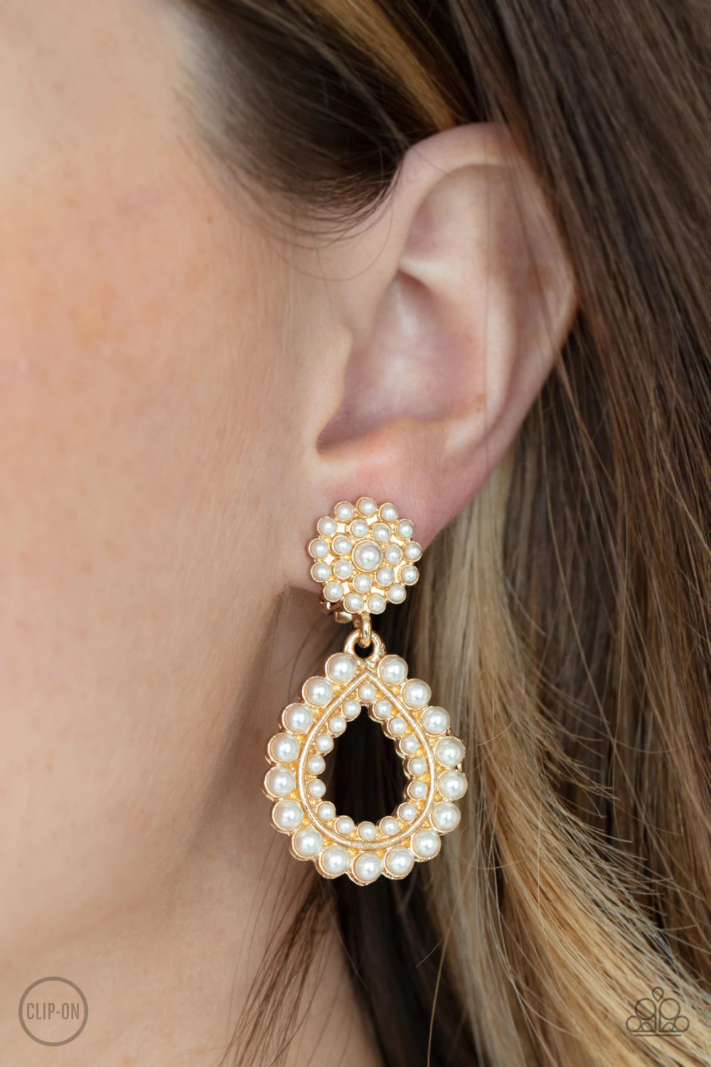 Paparazzi Accessories Discerning Droplets - Gold *Clip-On Droplets of pearls dot the surface of a gold teardrop frame that suspends from a round pearl encrusted disc for a classic finish. Earring attaches to a standard clip-on fitting. Sold as one pair of