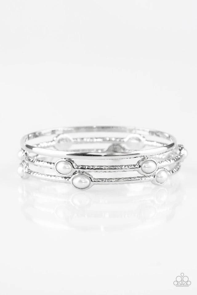 Paparazzi Accessories Bangle Belle - White Delicately hammered in shimmer, a pair of pearly white encrusted bangles joins a smooth silver bangle around the wrist for a refined fashion. Jewelry