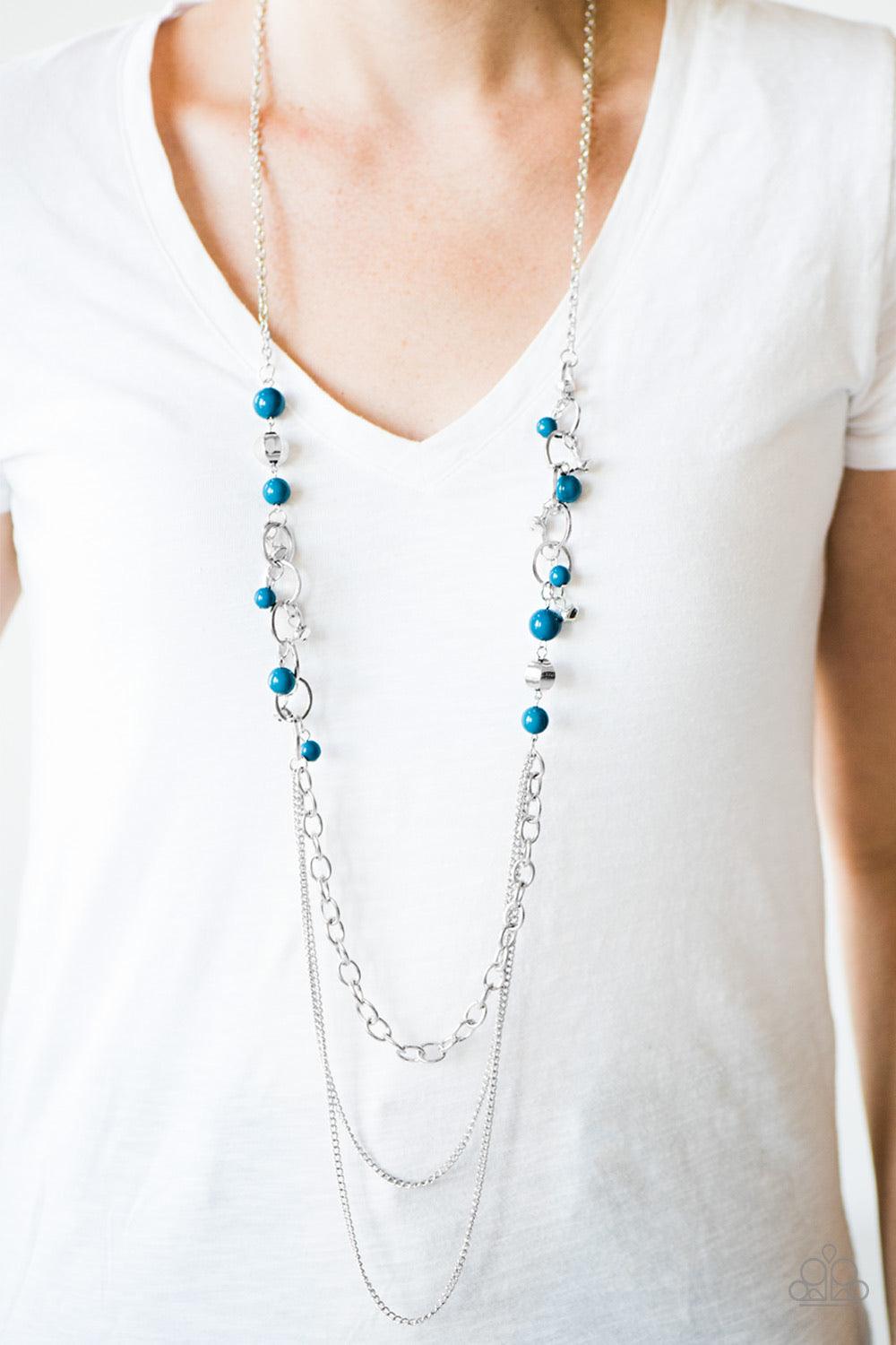 Paparazzi Accessories Carefree and Capricious - Blue Polished blue and faceted silver beads trickle along shimmery silver hoops for an asymmetrical look. The colorful beading gives way to layers of shimmery silver chain for a seasonal finish. Features an